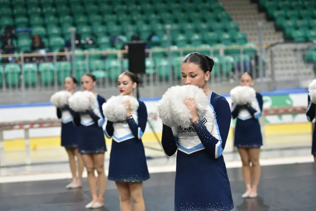 Αθλήτρια Cheerleading με pom στο ταπί